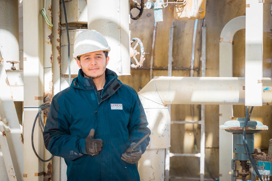 Engineer in safety gear within an industrial setting in Libya, pipes and machinery visible